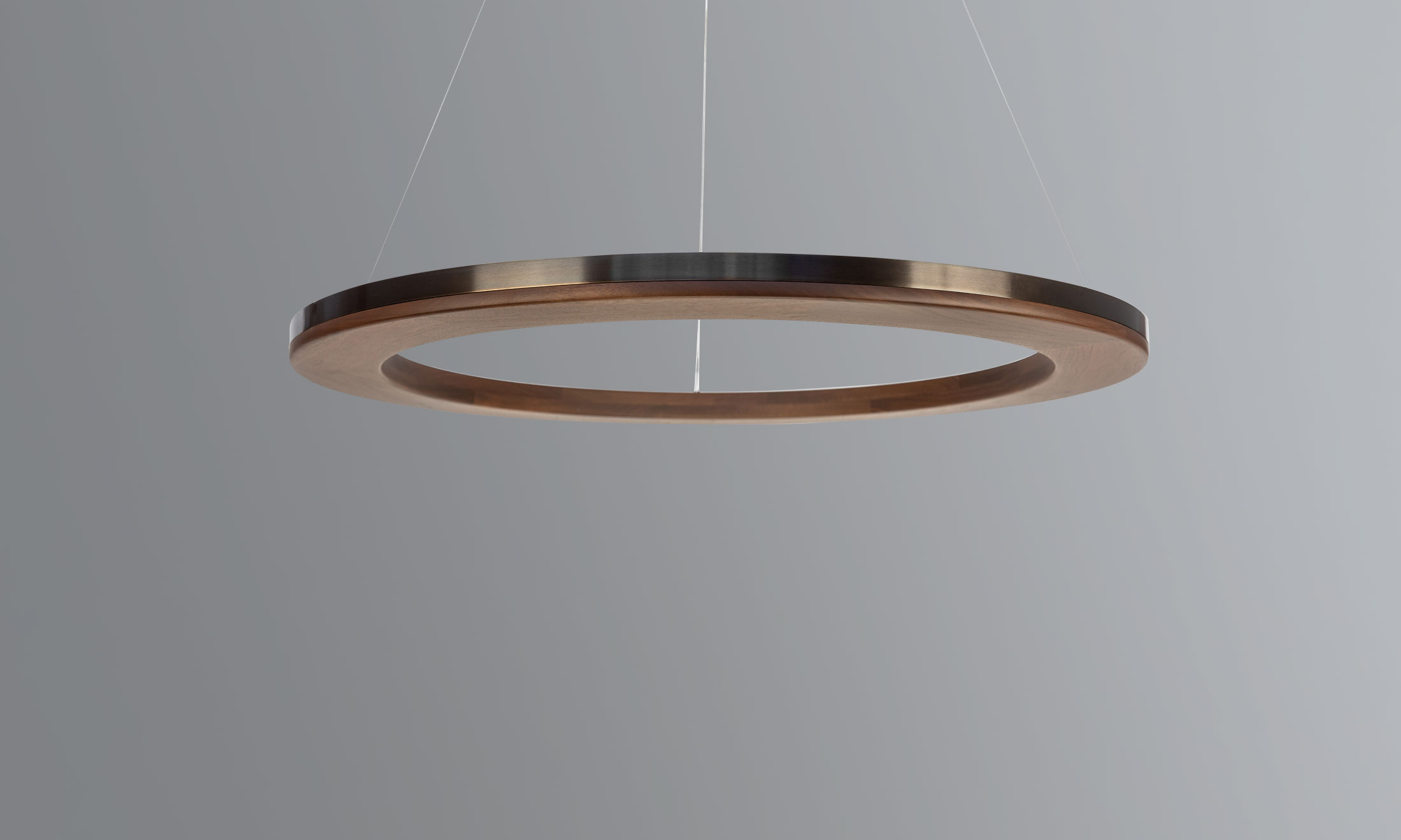 Made of walnut with a smooth metal inlay, Boyd Lighting's Numi is as contemporary as it is refined. Designed with integrated LED uplighting, this chandelier will provide gentle glowing illumination to any space